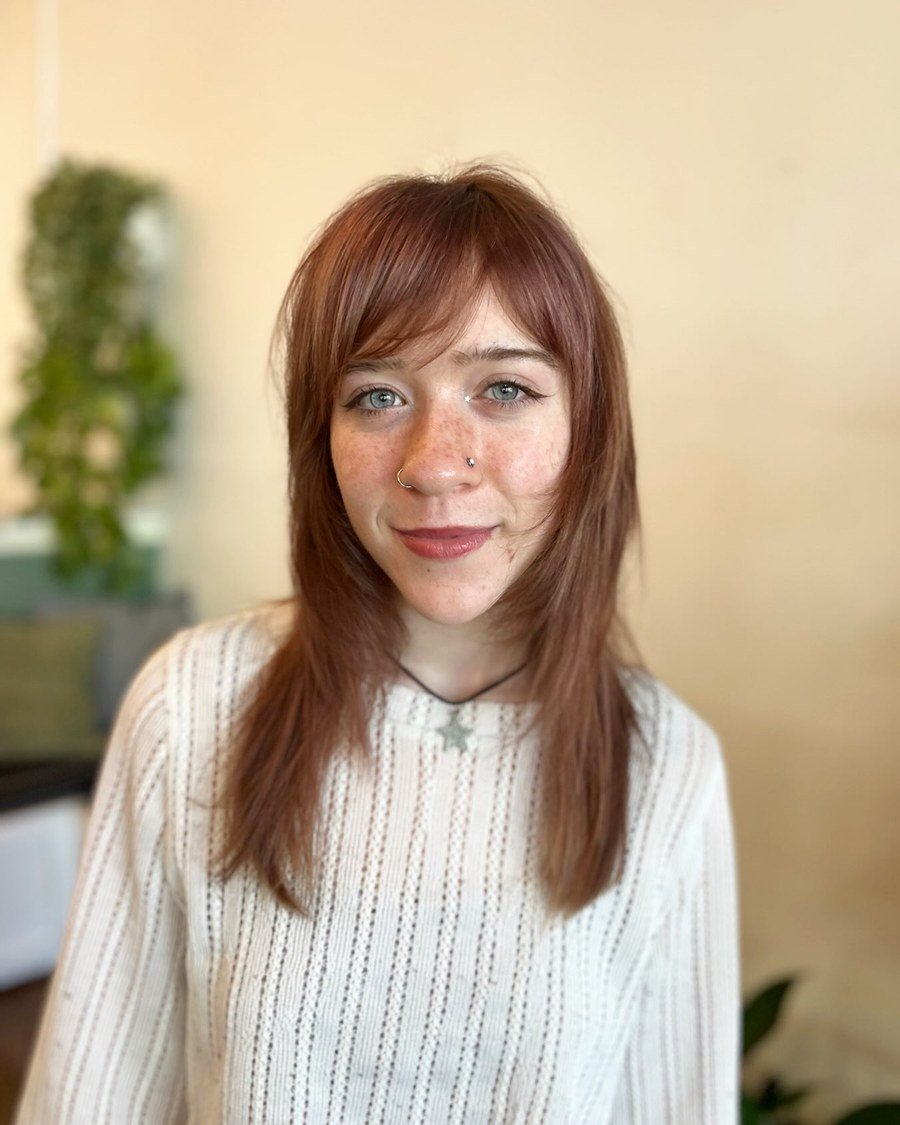 Front-facing portrait of shoulder-length reddish-brown hair with wispy bangs