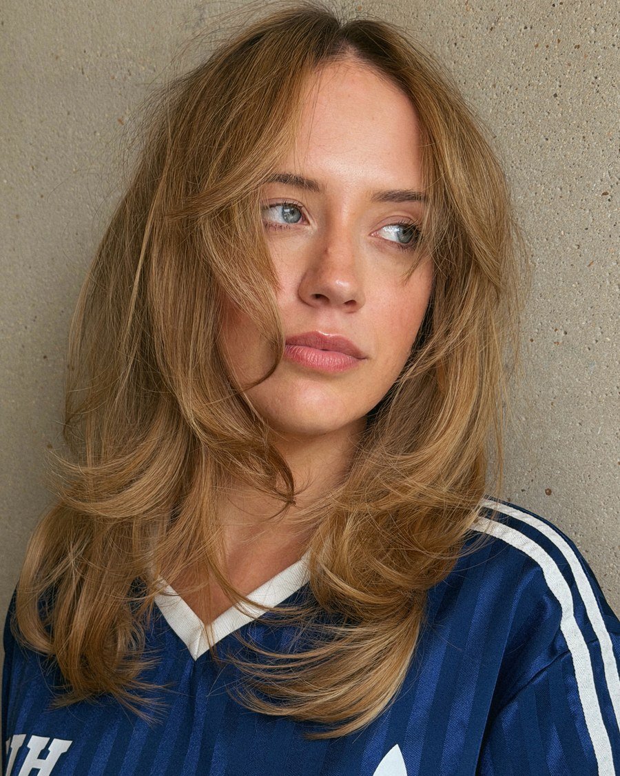 Close-up portrait of shoulder-length wavy honey-blonde hair with face-framing layers