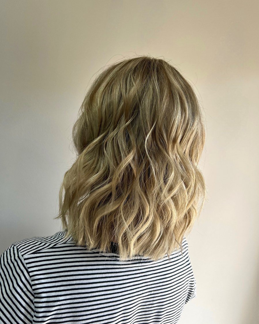 Back view of shoulder-length multi-tonal blonde bob styled in loose beach waves