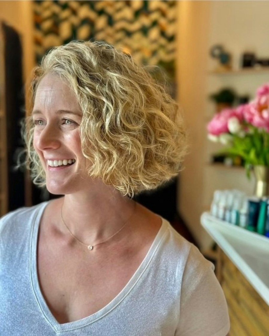 Smiling woman with shoulder-length curly blonde soft layered bob