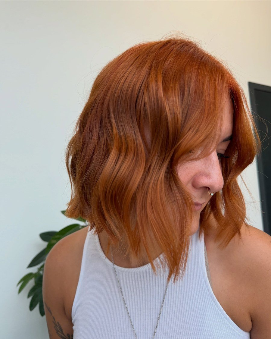 Close-up portrait of vibrant copper-red wavy shoulder-length bob