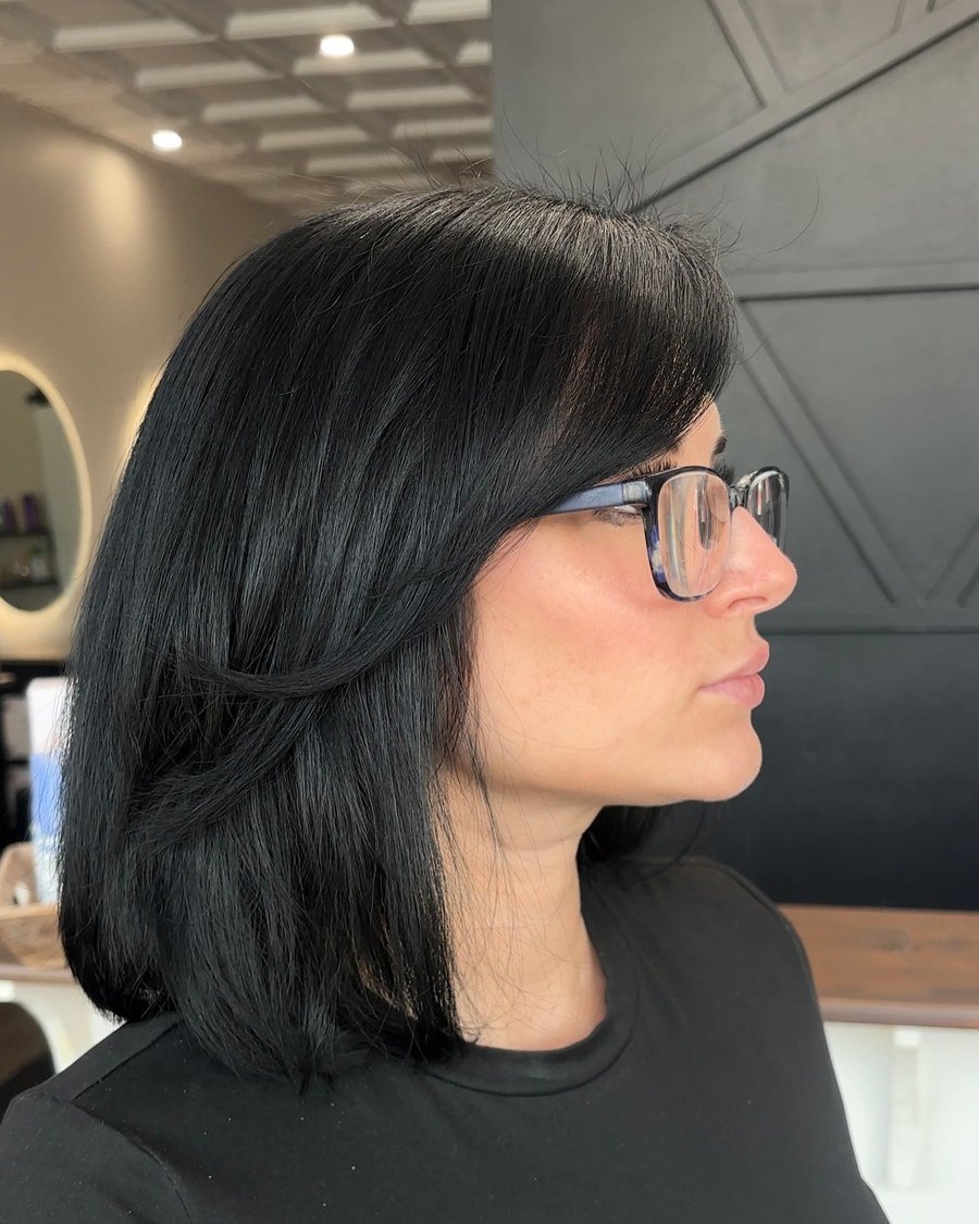 Side-profile portrait of straight glossy jet-black lob with sweeping bangs