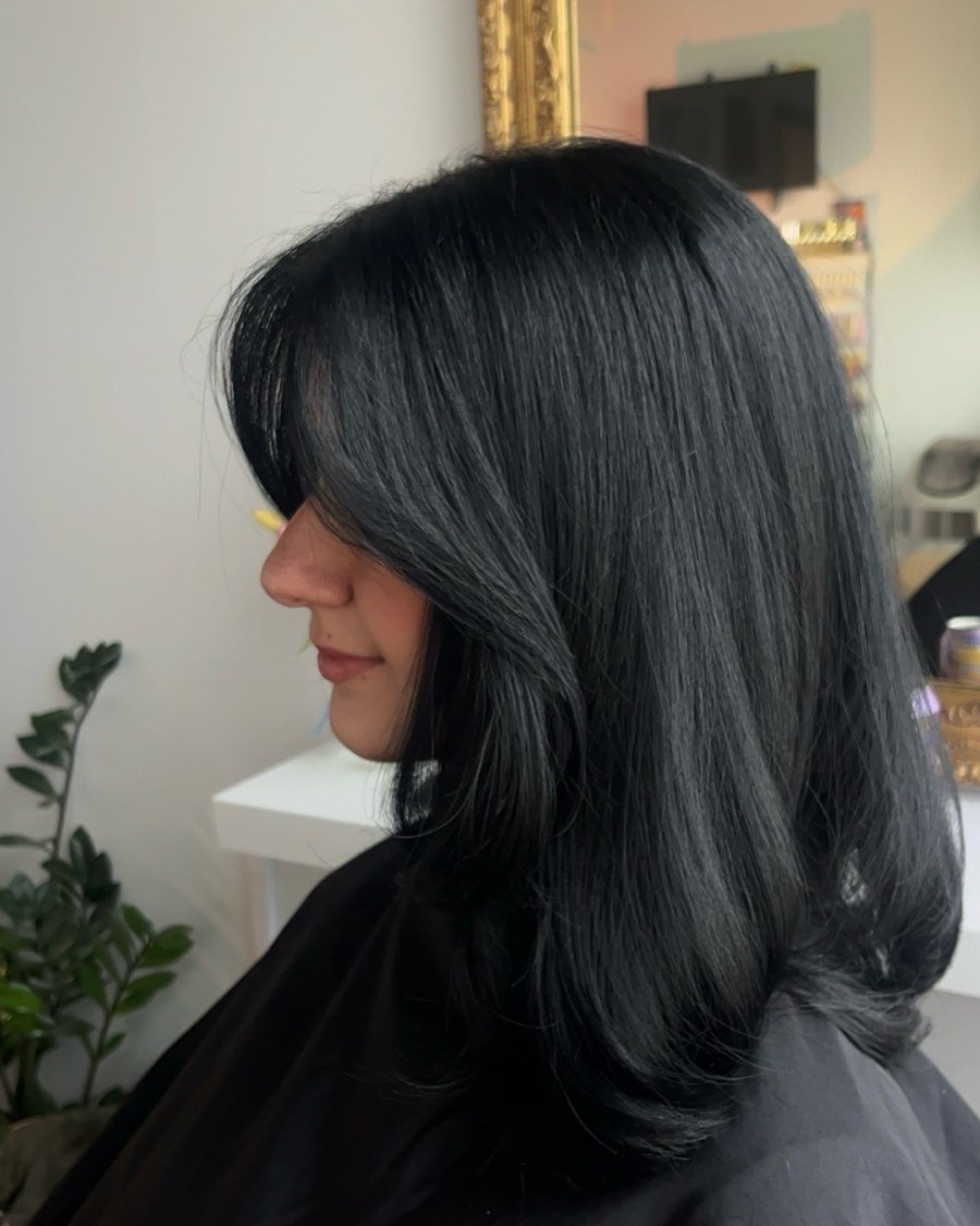 Side profile of thick straight black hair just below shoulders with blended long layers