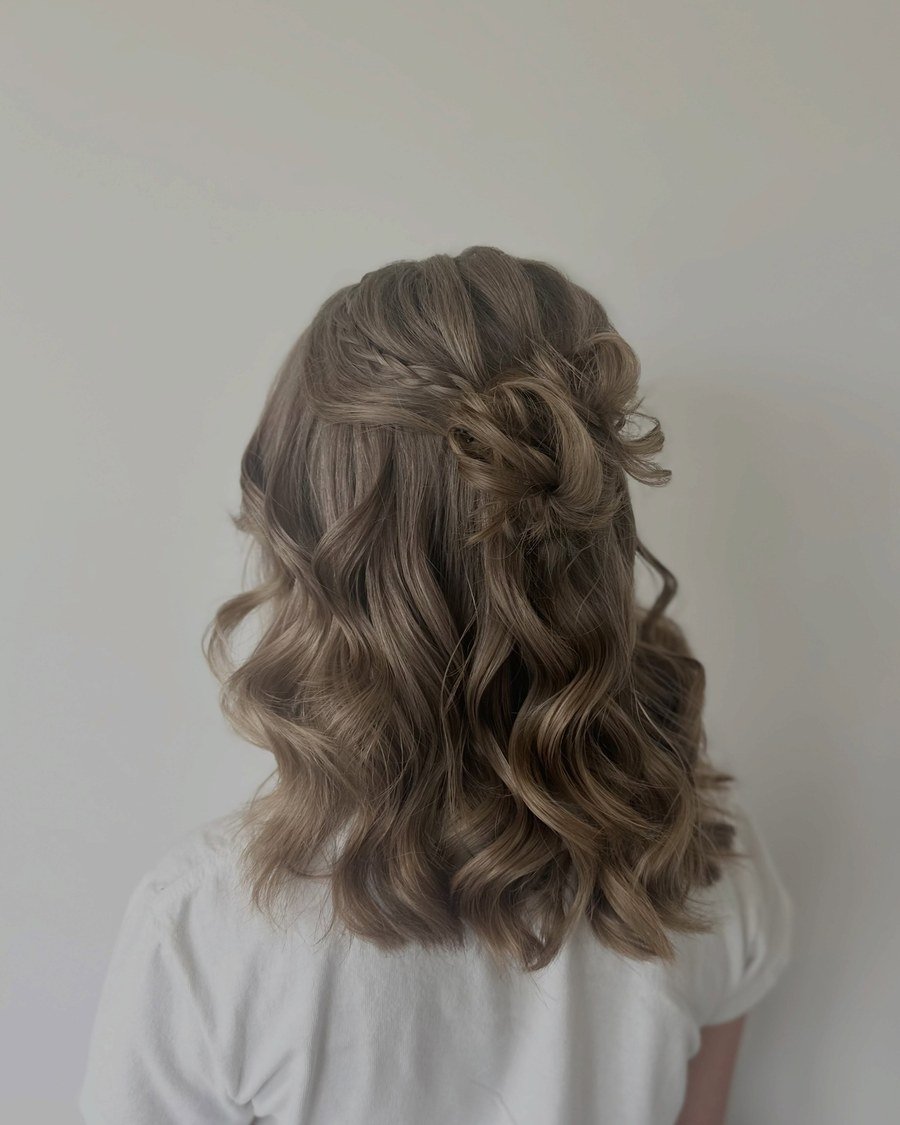Rear view of shoulder-length light brown wavy hair in a half-updo with small braid
