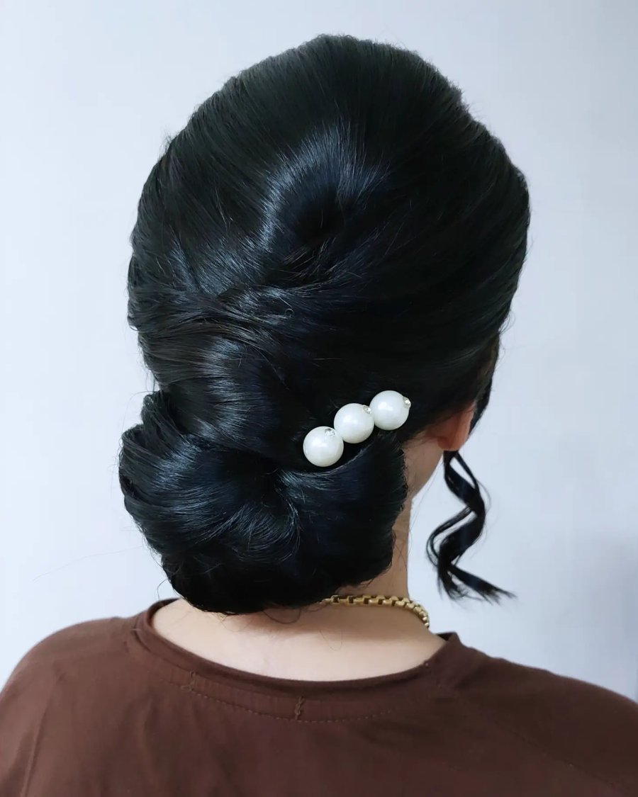 Elegant Low Chignon with Pearl Pins - holiday hairstyle idea for women